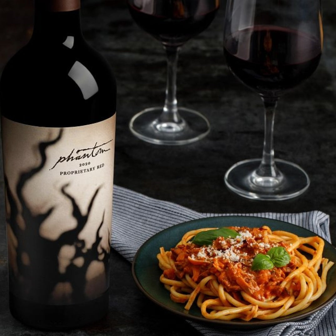 Load image into Gallery viewer, Bogle Phantom Proprietary Red Blend Wine bottle next to a plate of spagetti and two wine glasses