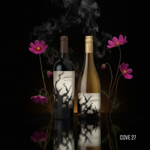 Load image into Gallery viewer, Two BOGLE PHANTOM wine bottles, one red blend and one chardonnay, with labels and pink flowers on a reflective surface against a black background.