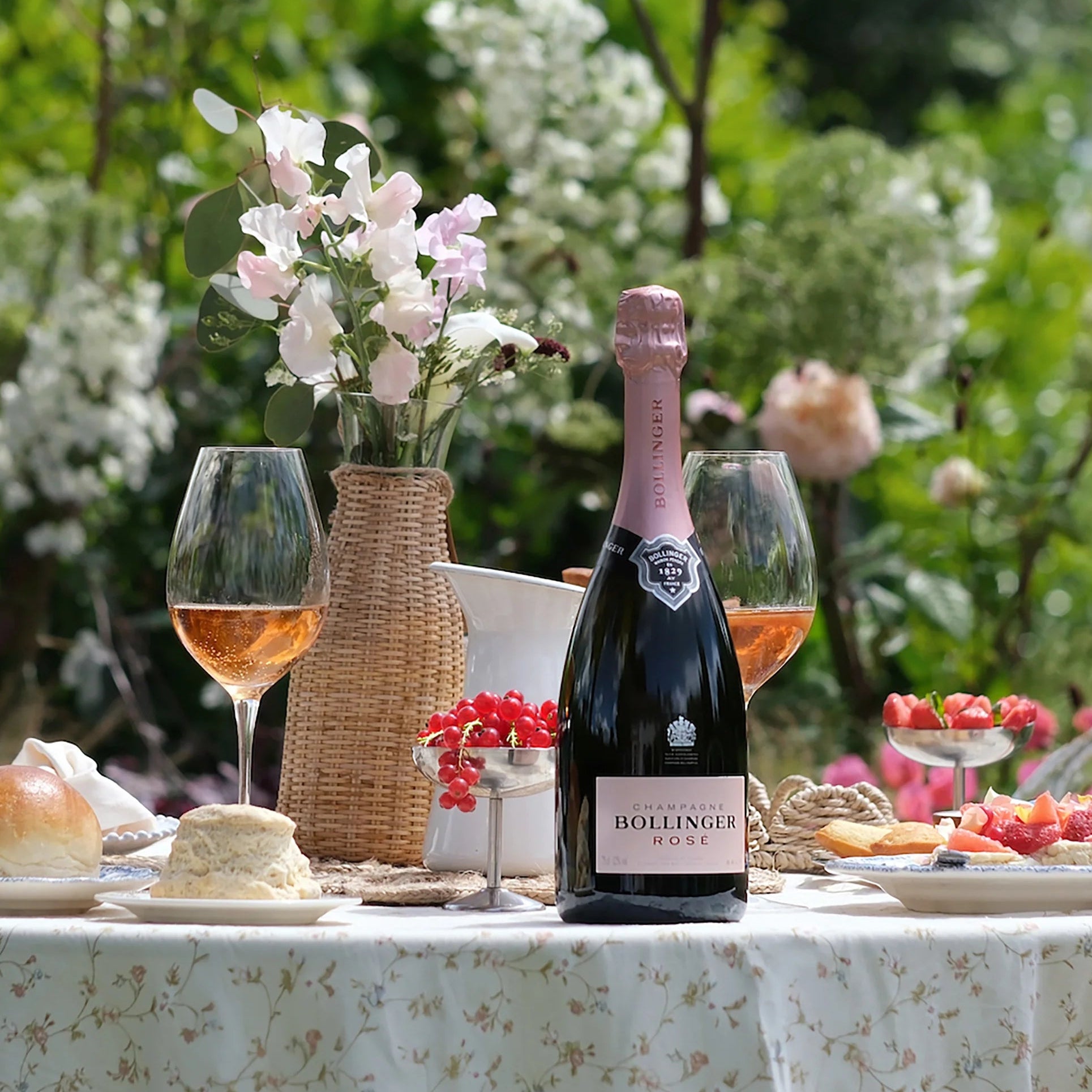 Load image into Gallery viewer, Bollinger Rose champagne bottle on a table with glasses and snacks in a garden setting