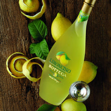 Load image into Gallery viewer, Limoncino Bottega bottle surrounded by lemons on a wooden surface