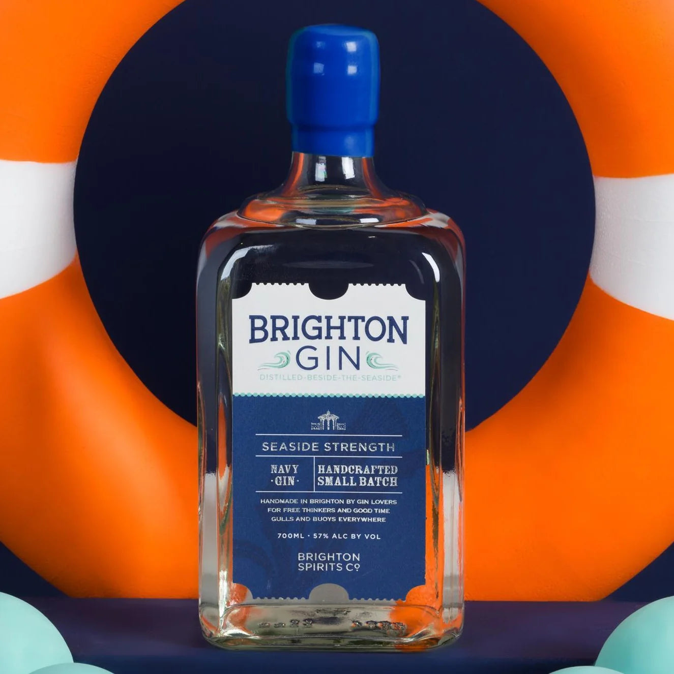 Load image into Gallery viewer, Bottle of Brighton Gin with a life buoy in the background