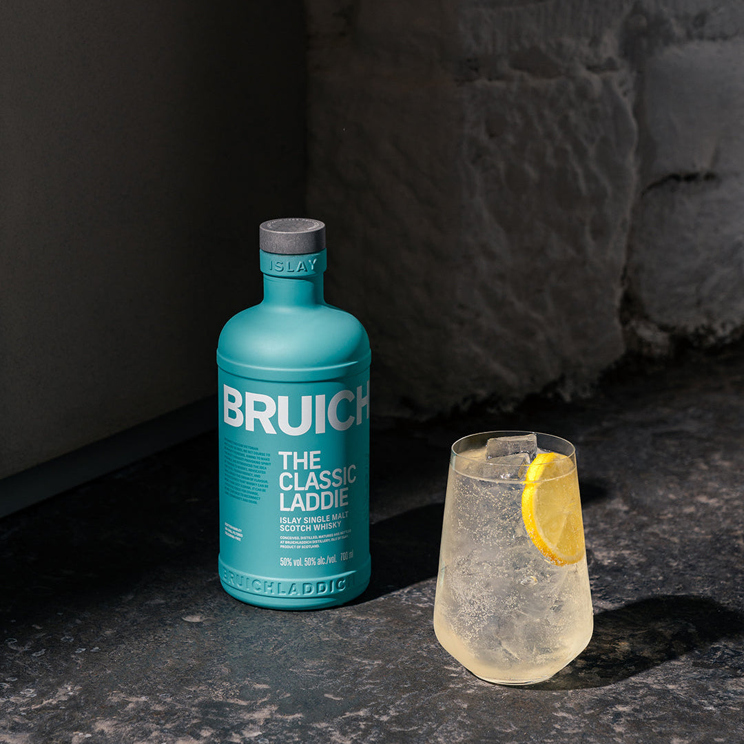 Load image into Gallery viewer, Bruichladdich bottle with a glass of liquid on a dark surface