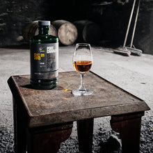 Load image into Gallery viewer, A bottle of Bruichladdich Port Charlotte 10 year old whisky and a glass of whisky on a table in a dark room