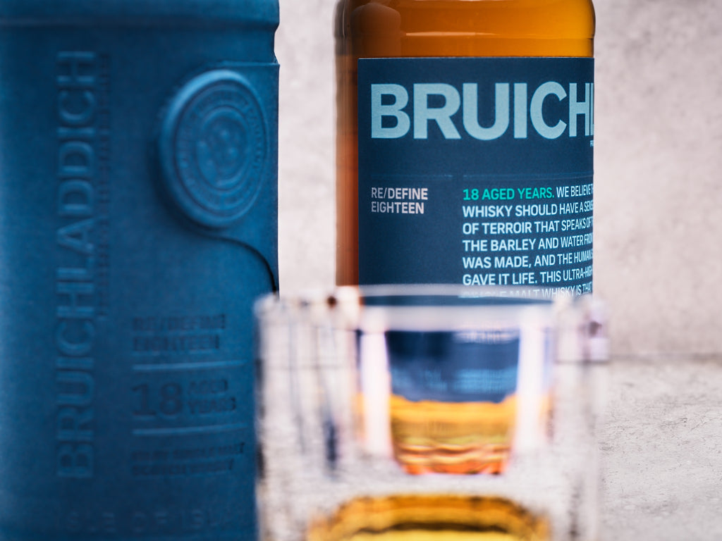 Bruichladdich 18 year old whisky bottle with a glass of whisky in front