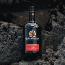 Load image into Gallery viewer, Bottle of Bunnahabhain 12 year old whisky on a rocky surface
