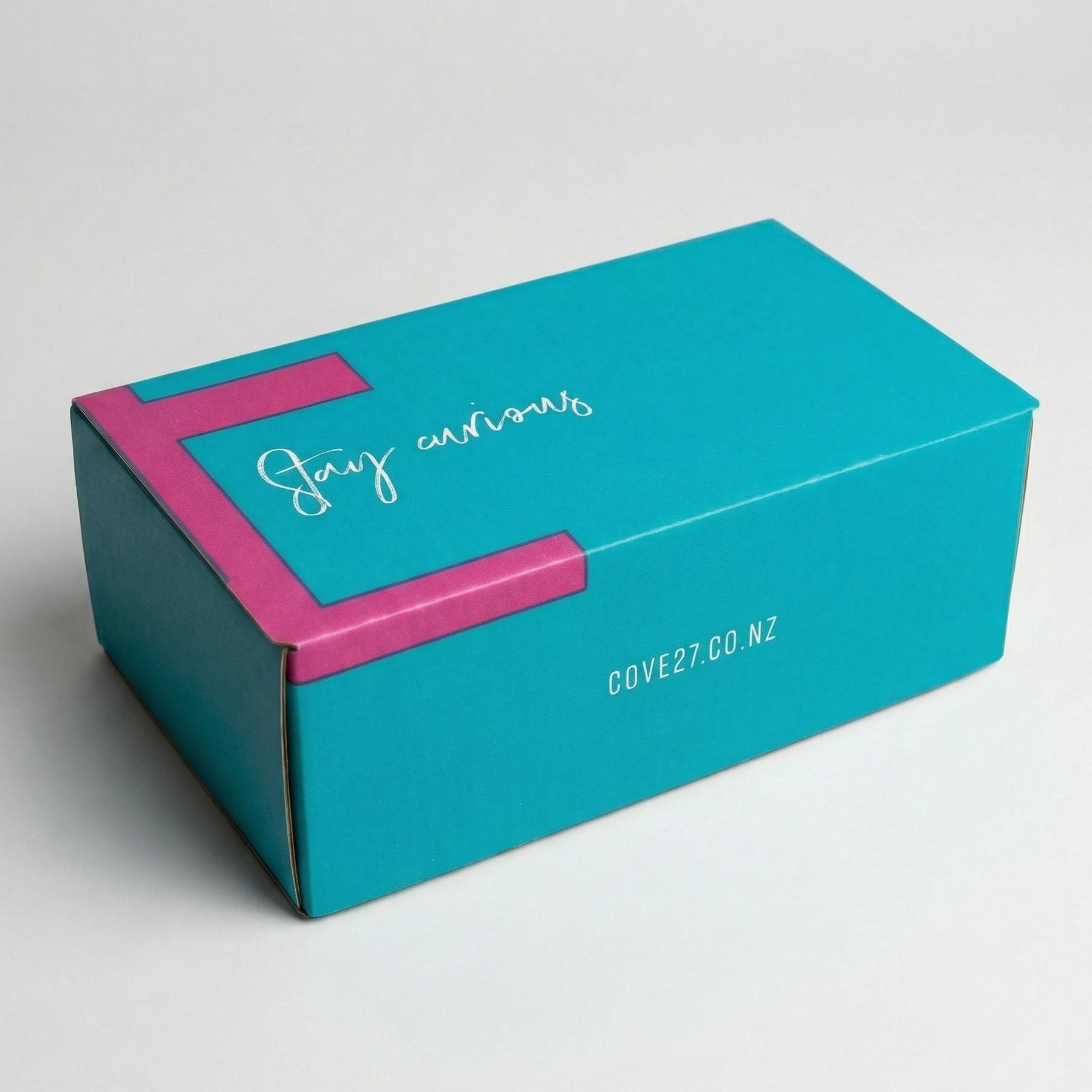 Load image into Gallery viewer, COVE 27 teal box with magenta accent and 'Stay curious' text on a white background