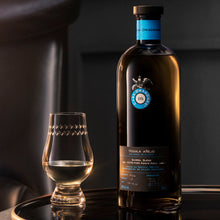 Load image into Gallery viewer, Casa Dragones Anejo Tequila bottle and glass on a dark surface with a blurred background