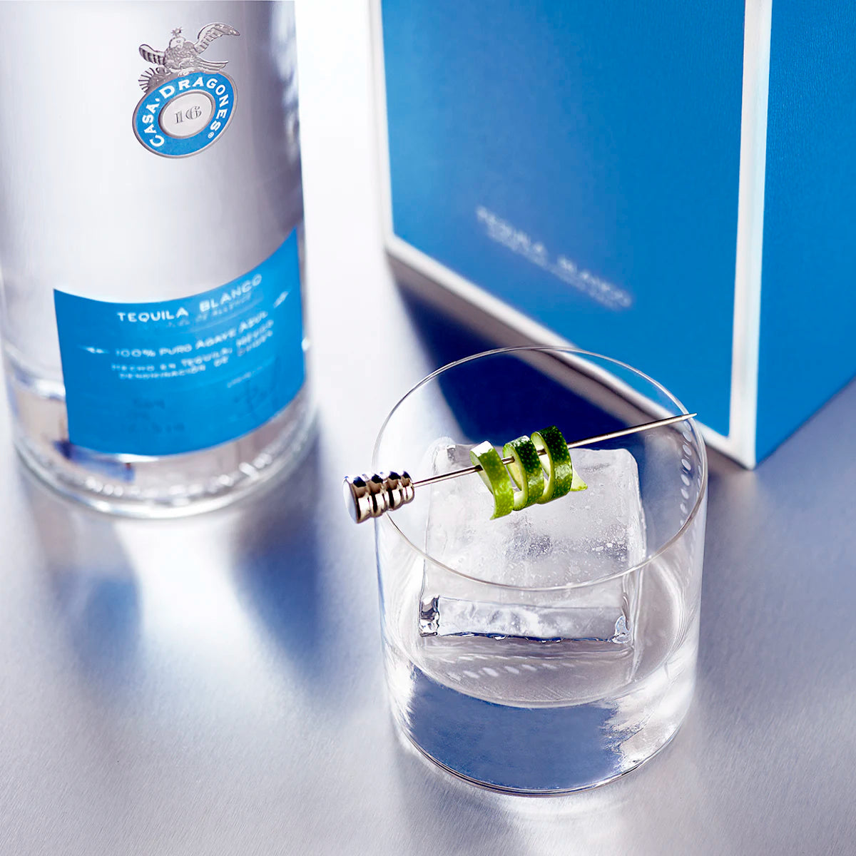 Load image into Gallery viewer, Tequila bottle with a glass of tequila and ice cube on a reflective surface