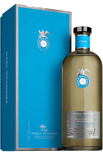 Load image into Gallery viewer, A bottle of Casa Dragones Reposado Mizunara Tequila next to its blue presentation gift box, featuring a light olive-green liquid in a clear glass bottle with a blue and silver label.
