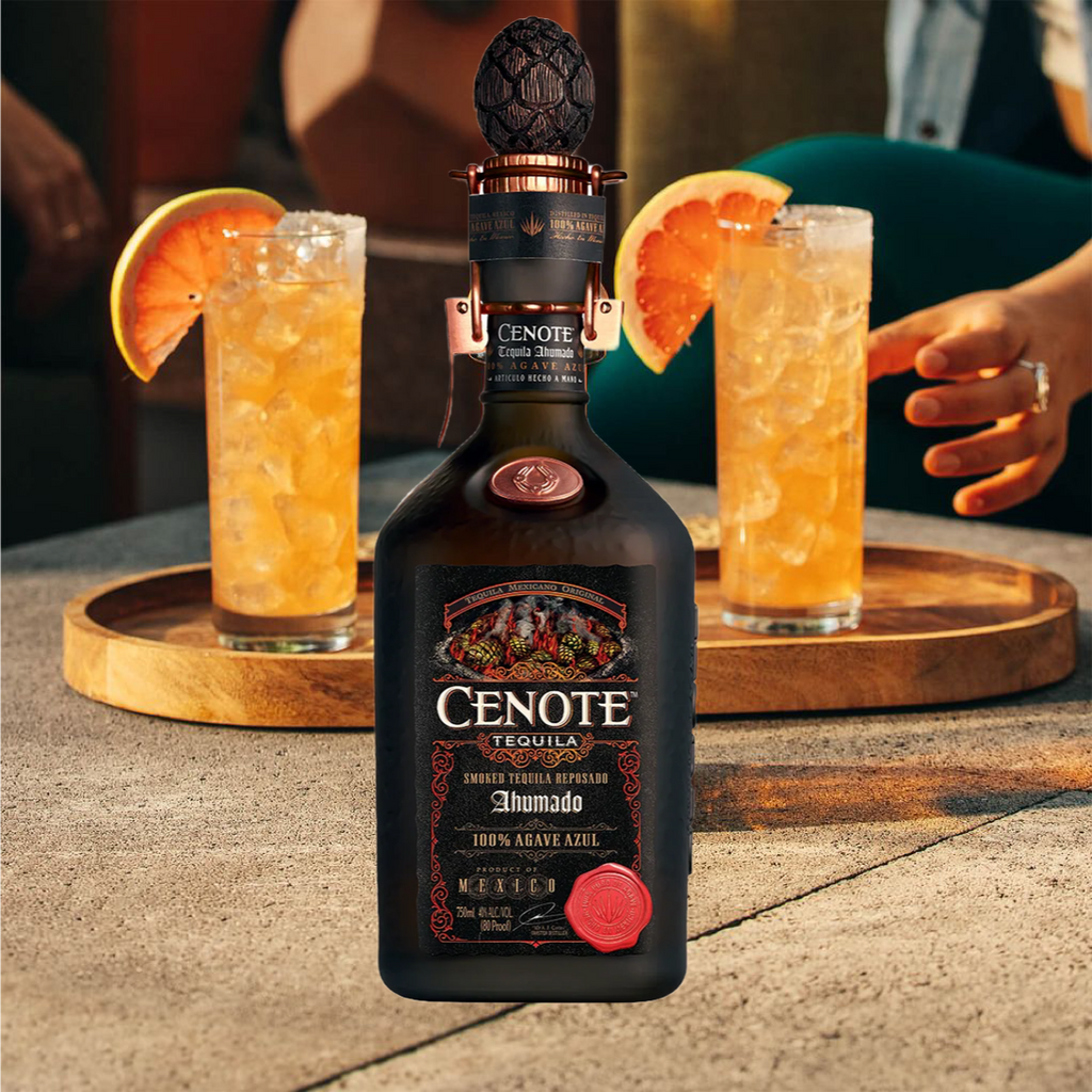 Cenote Ahumado Reposado Tequila bottle with two cocktails on a wooden tray