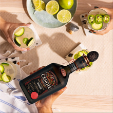 Load image into Gallery viewer, Bottle of Cenote tequila with cocktails and limes on a table