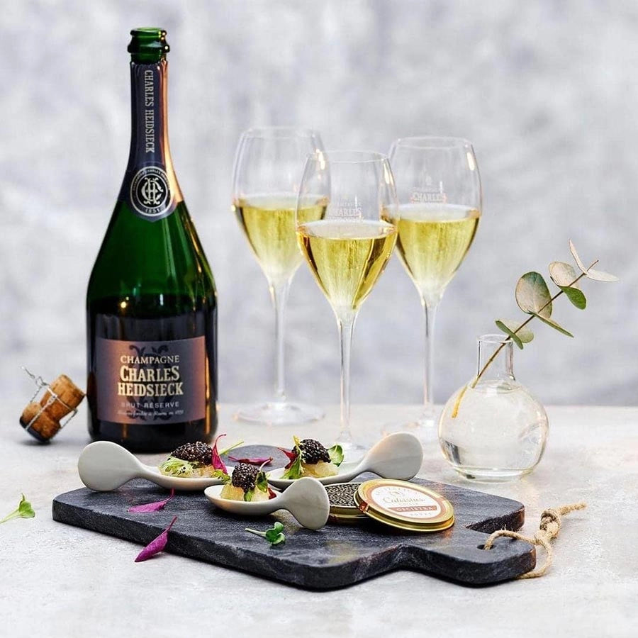 Load image into Gallery viewer, A bottle of champagne and three glasses with a board of caviar on a light background