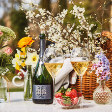 Load image into Gallery viewer, Bottle of Charles Heidsieck champagne with two glasses on a table outdoors, surrounded by flowers and strawberries.