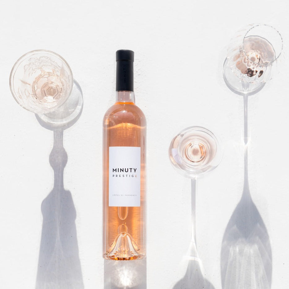 Load image into Gallery viewer, Bottle of Minuty Rosé wine with decorative glassware on a white background