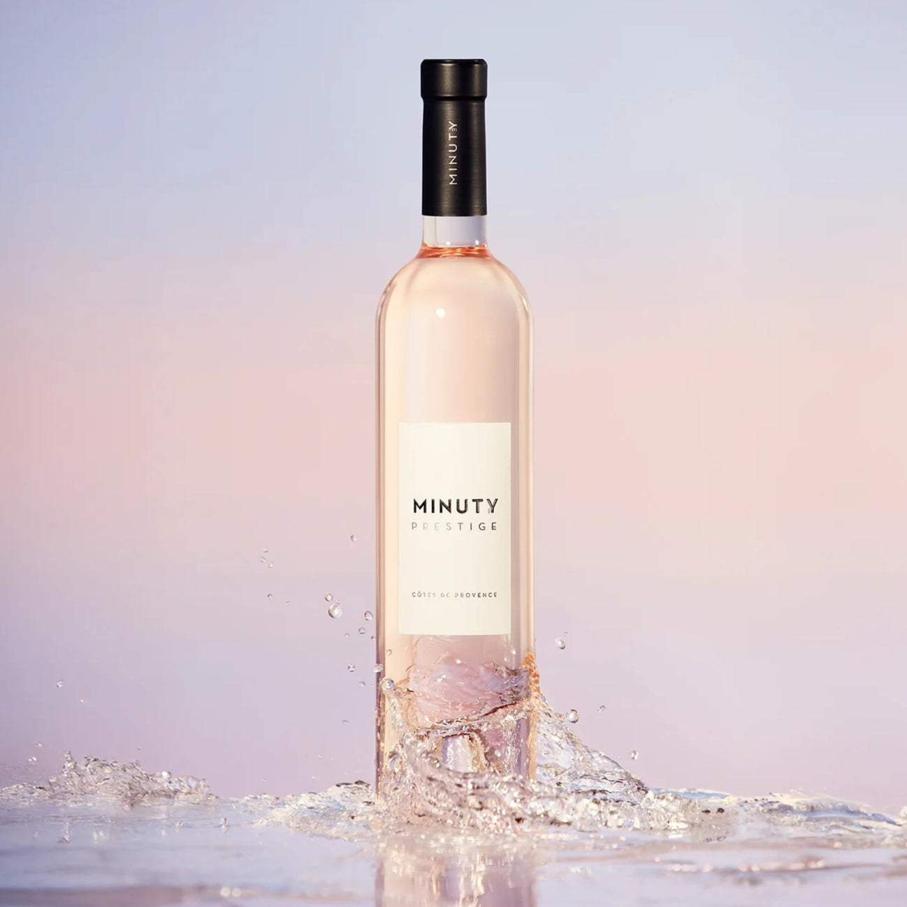 Load image into Gallery viewer, Bottle of Minuty Rosé wine with a soft gradient background