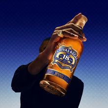 Load image into Gallery viewer, Person holding a bottle of Chivas Regal 18 against a blue gradient background