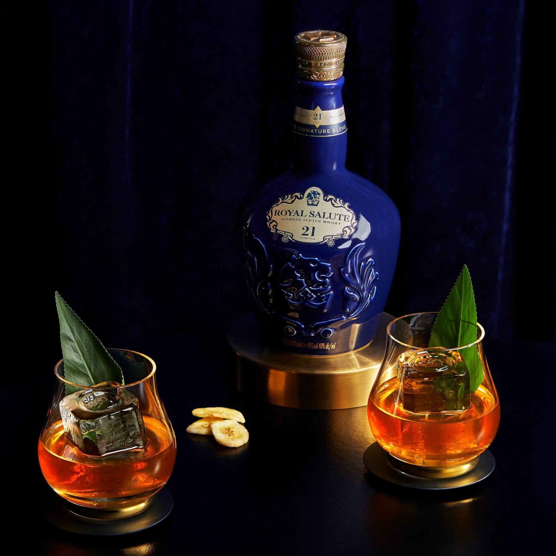 Load image into Gallery viewer, Bottle of Chivas Regal Royal Salute 21 Year Old Signature Blend Scotch Whisky with two glasses of amber liquid on a dark background