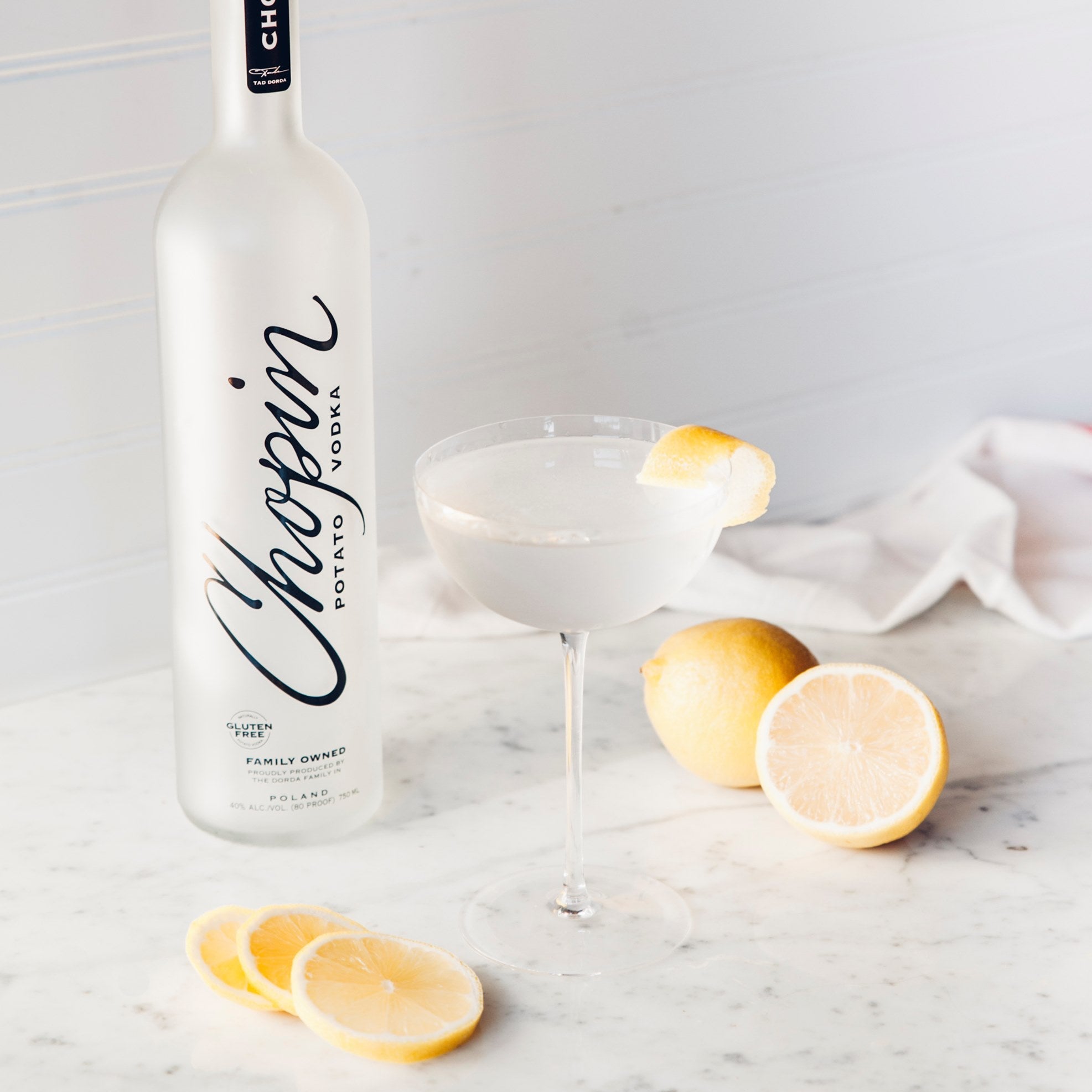 Load image into Gallery viewer, Chopin Potato Vodka bottle with a cocktail glass and lemons on a marble surface
