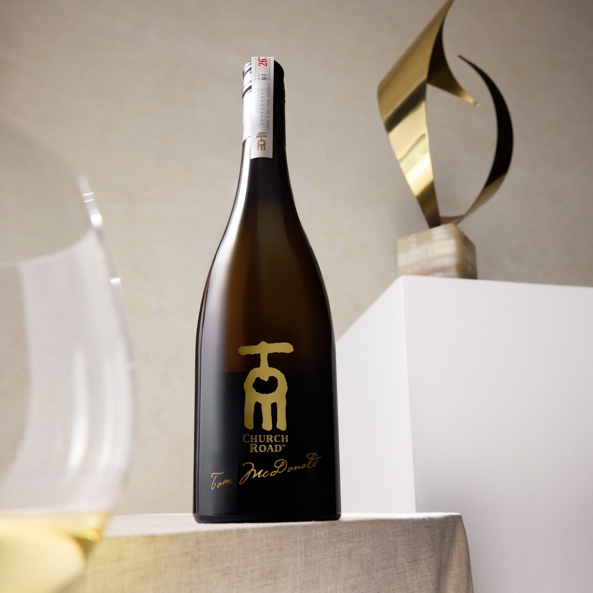 Load image into Gallery viewer, Bottle of Church Road TOM Chardonnay wine with a decorative background