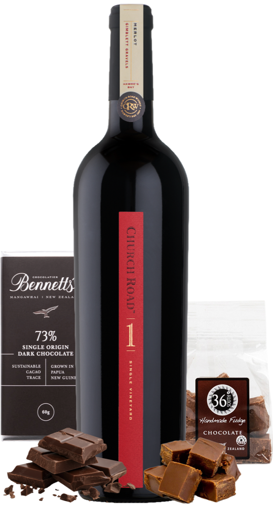 A bottle of Church Road 1 Merlot red wine centred on a white background, flanked by chocolate products: a Bennett's 73% dark chocolate bar on the left, a bag of 36% handmade fudge chocolate on the right, and scattered chocolate pieces at the base.