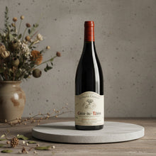 Load image into Gallery viewer, Charvin Cotes du Rhone wine bottle on a wooden table with a vase of flowers in the background