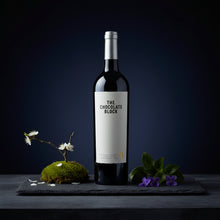 Load image into Gallery viewer, Wine bottle labeled &#39;The Chocolate Block&#39; on a dark surface with decorative elements.