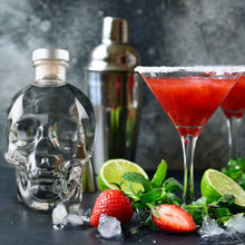 Load image into Gallery viewer, Two red cocktails in martini glasses with a Crystal Head Vodka bottle and cocktail shaker on a dark surface.