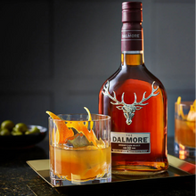 Load image into Gallery viewer, Dalmore whisky bottle with a cocktail garnished with orange peel on a dark surface