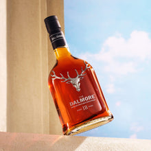 Load image into Gallery viewer, Bottle of Dalmore 18 year old 
whisky against a blue sky and beige wall
