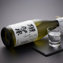 Load image into Gallery viewer, Sake bottle and glass on a dark surface with a gray background