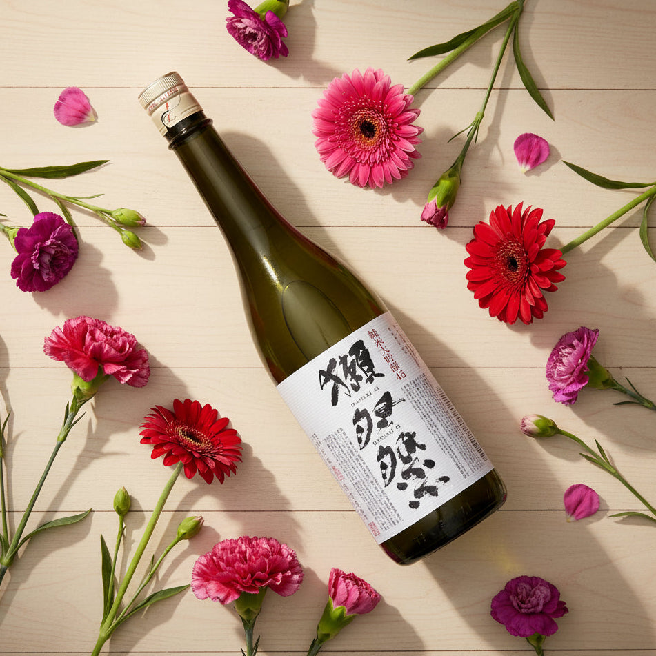 Load image into Gallery viewer, Bottle of sake with a floral arrangement on a wooden surface