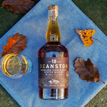 Load image into Gallery viewer, Deanston 18 year old whisky bottle with a glass on a blue cloth with autumn leaves