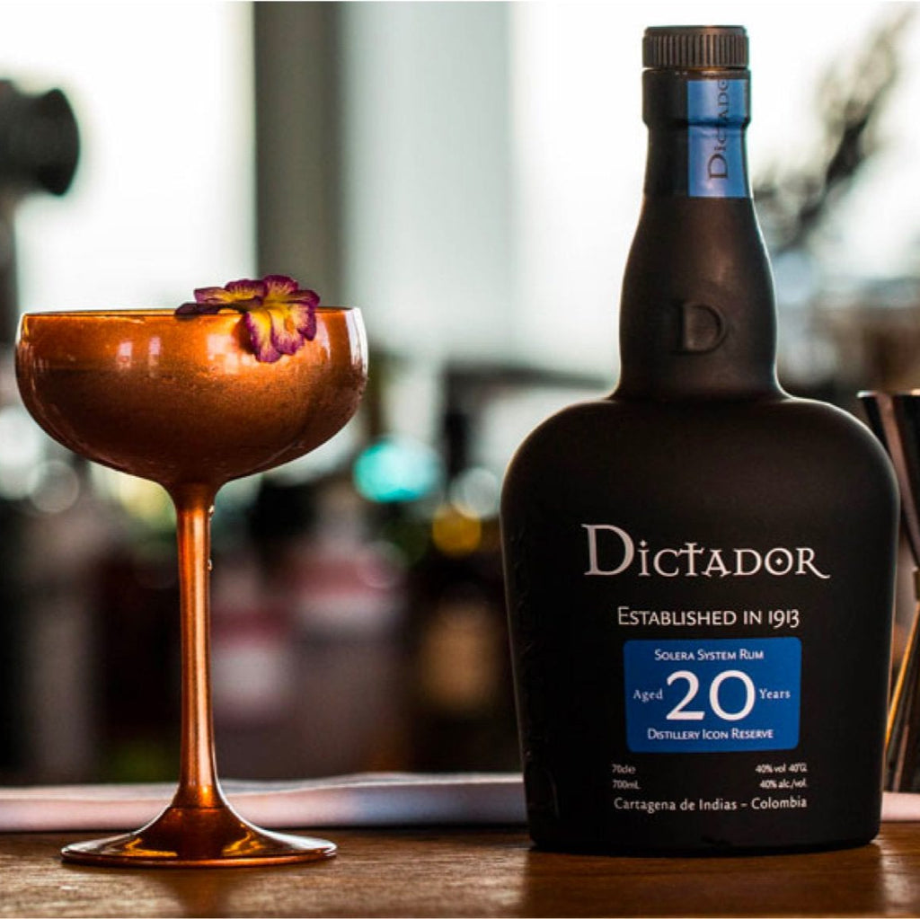 Dictador r20 year old um bottle with a cocktail on a bar counter