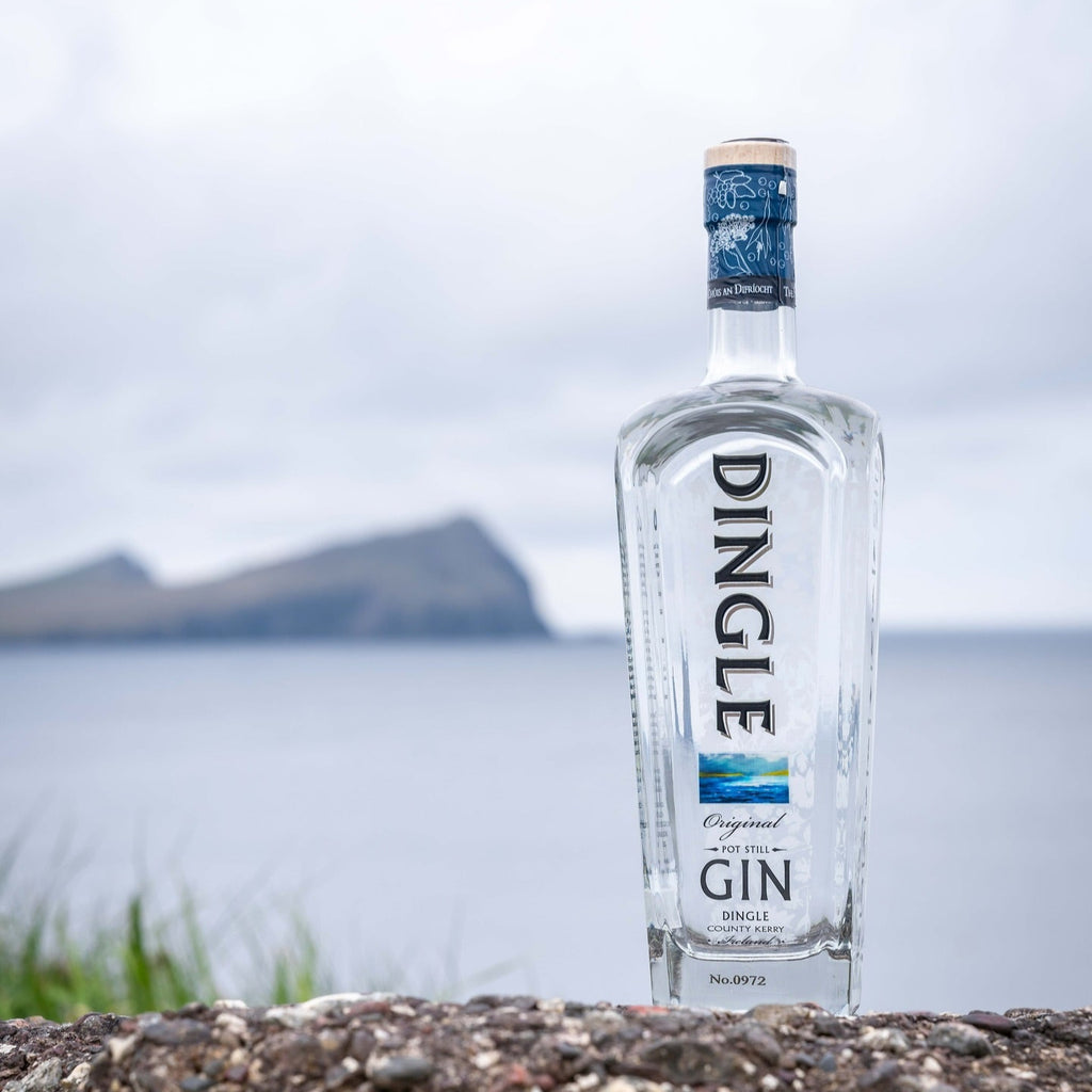 Dingle gin bottle on a rocky surface with a scenic background