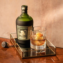 Load image into Gallery viewer, Diplomatico rum bottle with a glass of whiskey on a reflective tray against a neutral background