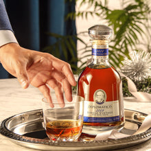 Load image into Gallery viewer, Bottle of Diplomatico rum and a glass on a tray with a blurred background