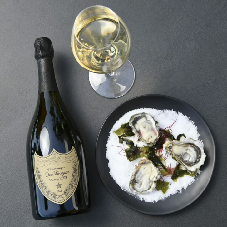 Load image into Gallery viewer, A bottle of Dom Perignon Champagne and oysters on a grey background
