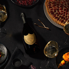 Load image into Gallery viewer, Bottle of DOM PERIGNON champagne with glasses and a cake on a dark table