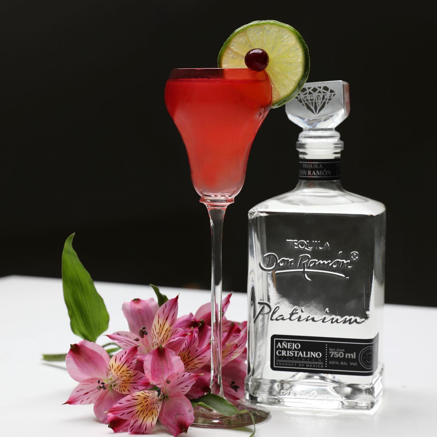Load image into Gallery viewer, Bottle of Don Ramon Platinum tequila with a cocktail and flowers on a white surface.