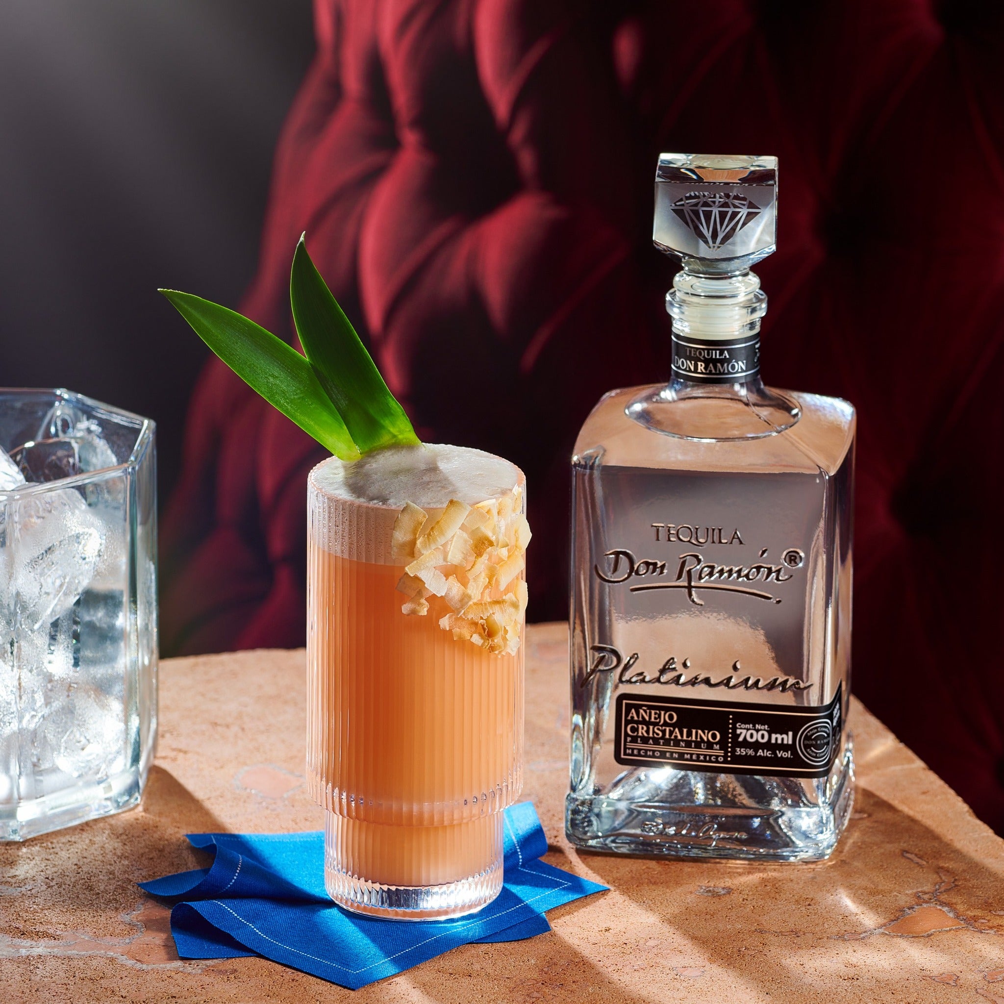 Load image into Gallery viewer, Tequila Don Julio Platinum bottle with a cocktail garnished with a leaf on a wooden surface.