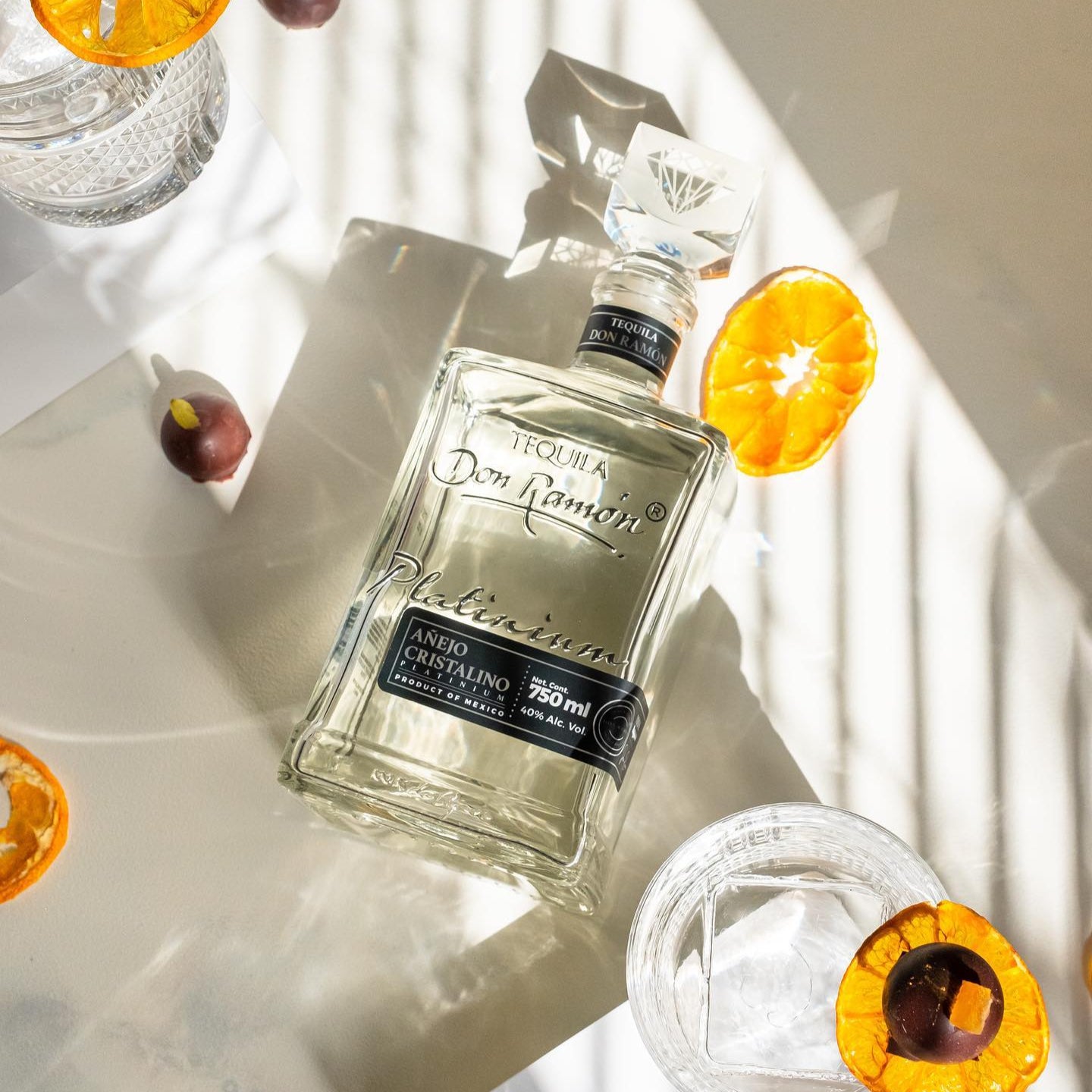 Load image into Gallery viewer, Bottle of Don Ramon tequila with orange slices on a white surface