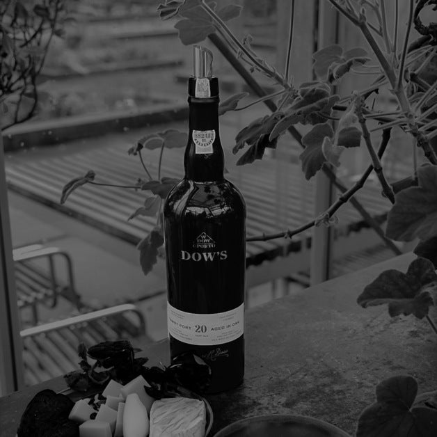 Load image into Gallery viewer, A bottle of port wine on a beach with some greenery 