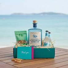 Load image into Gallery viewer, Drumshanbo Gunpowder Irish Gin gift set INCLUDING TONIC WATER AND FN DRIED LEMON GARNISH POUCH on a wooden surface with a scenic background