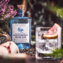 Load image into Gallery viewer, Bottle of Drumshanbo Gunpowder Irish Gin with a glass of gin and tonic on a decorative table.