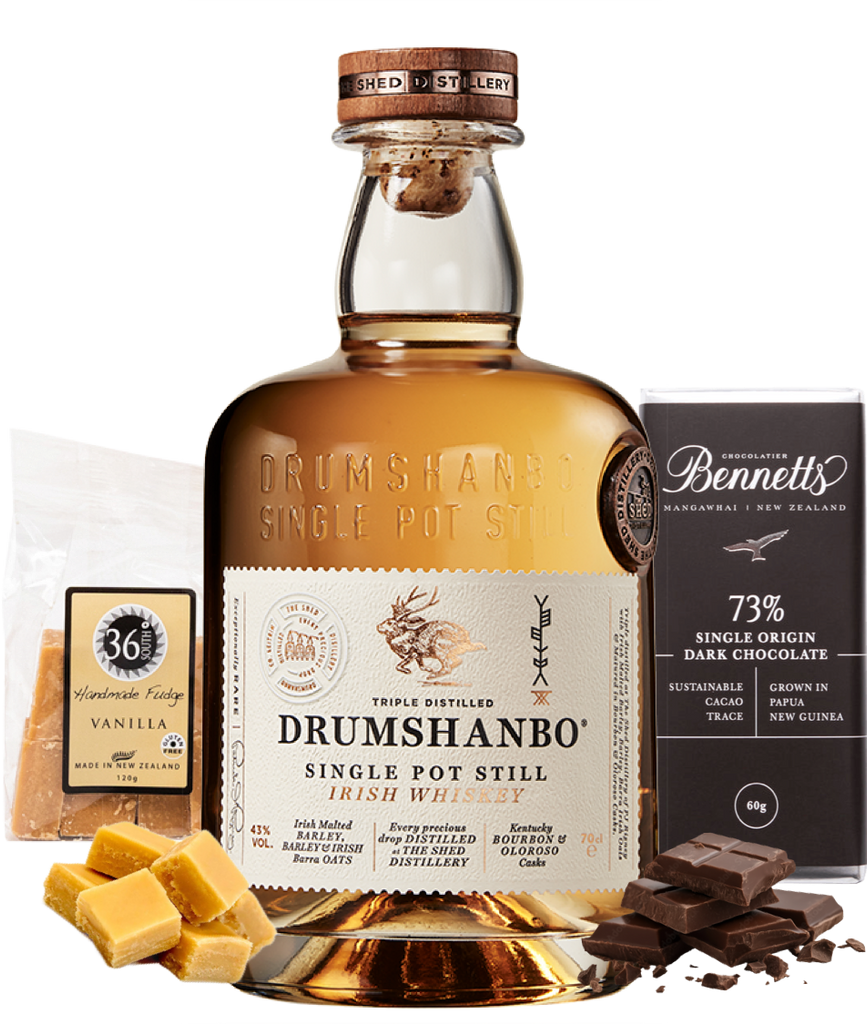 A bottle of Drumshanbo Single Pot Still Irish Whiskey centred on a white background, surrounded by flavour-themed gift items: a bag of 36 Degrees Vanilla fudge, vanilla fudge pieces, and a bar of Bennett's 73% Single Origin Dark Chocolate.
