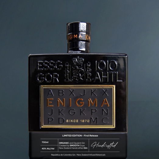 Black bottle of Enigma gin with gold text on a dark background