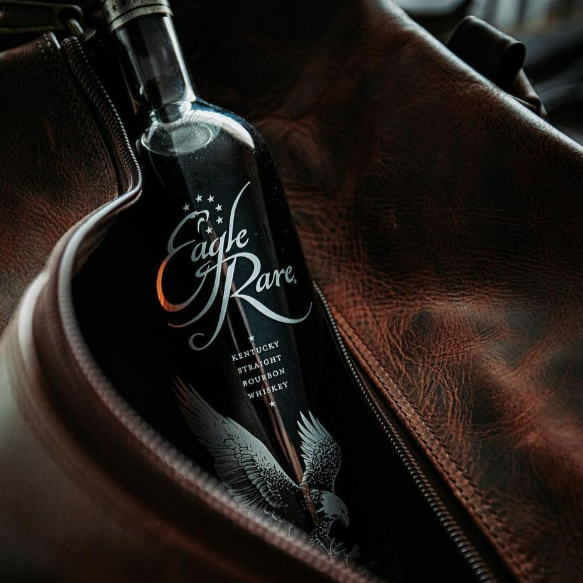 Load image into Gallery viewer, Bottle of Eagle Rare bourbon whiskey in a leather pouch.
