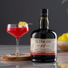 Load image into Gallery viewer, El Dorado 12 Year Old Rum bottle with a cocktail and lemons on a reflective surface.
