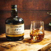 Load image into Gallery viewer, El Dorado Special Reserve 21-year-old rum bottle with a glass of rum on a wooden surface.