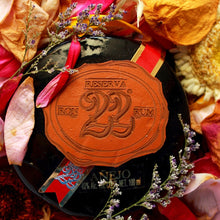 Load image into Gallery viewer, Rum bottle label with &#39;Reserva 22&#39; on a decorative background of flowers and leaves.